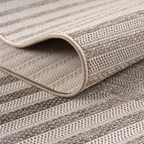 Beige geweven vloerkleed met een organisch lijnenspel in Japandi-stijl, liggend op een lichte houten vloer in een minimalistisch interieur.