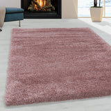 Roze hoogpolig fluffy shaggy vloerkleed in een woonkamer met openhaard